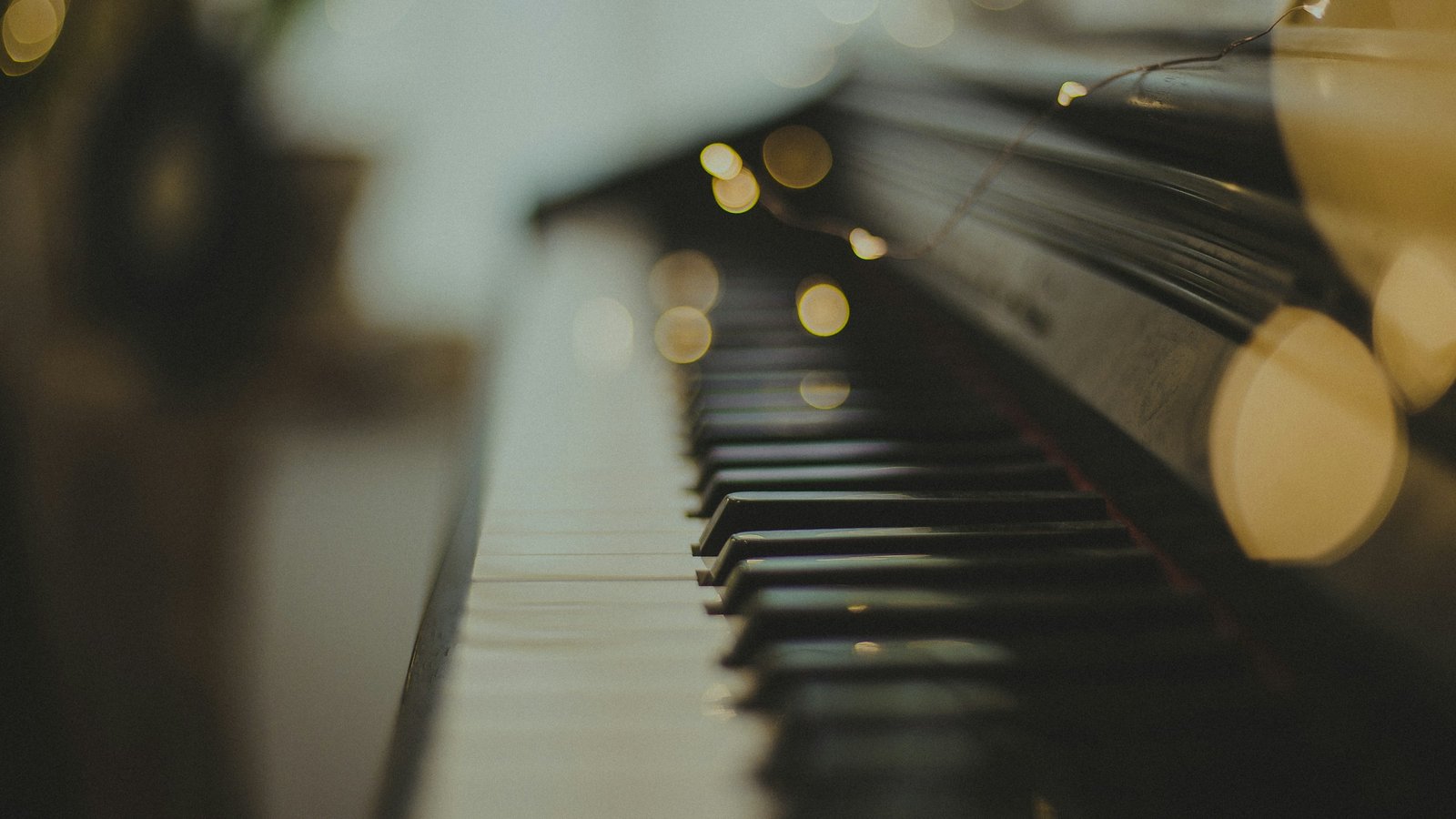 Warm close-up of piano keys lit by soft golden light