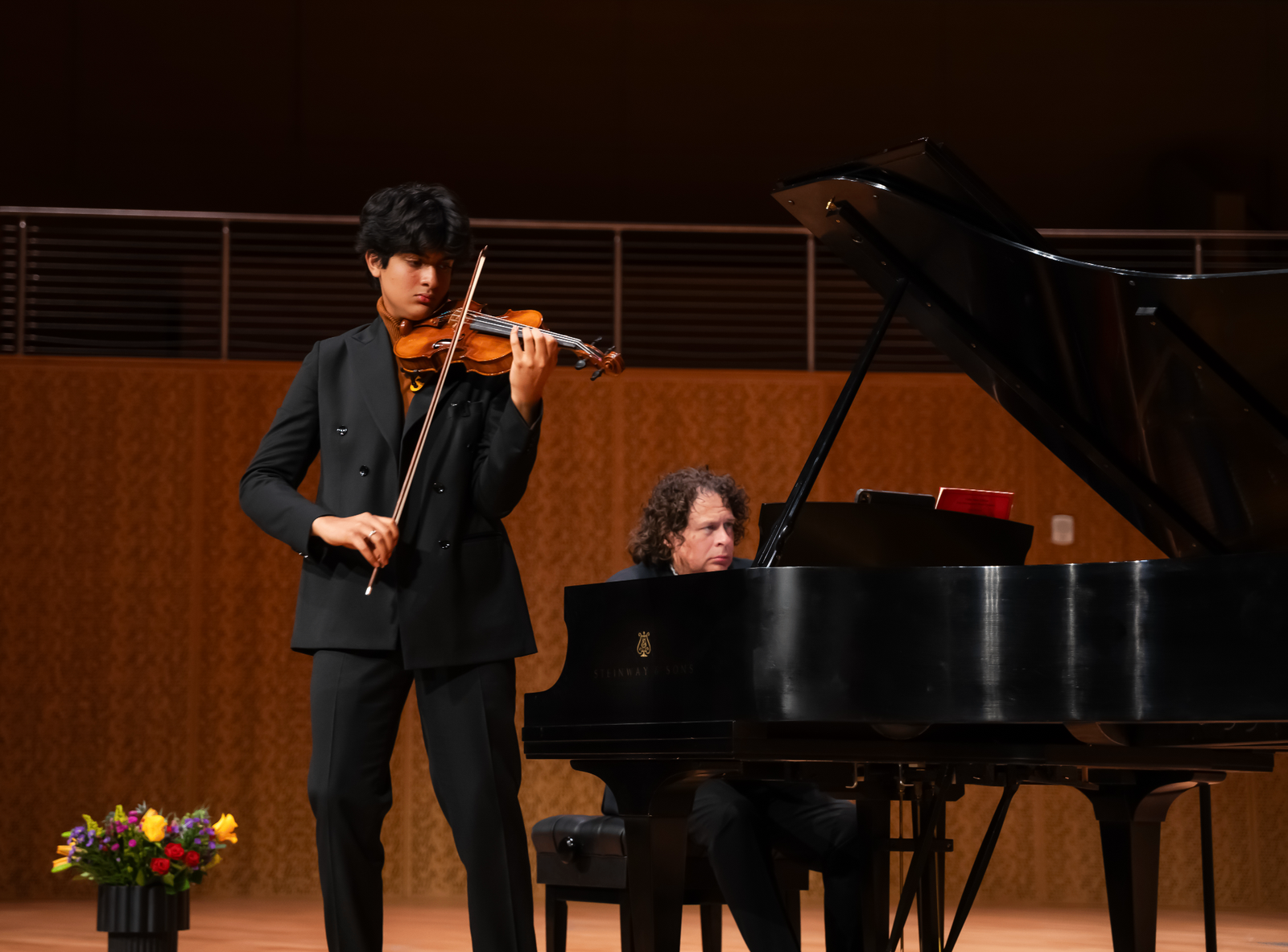 Jay Sriram on stage performing violin with his piano teacher Dr. Michael Schneider